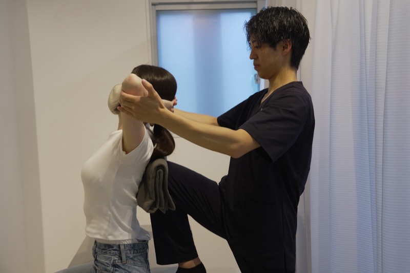 施術者が肩の動きを確認している様子
