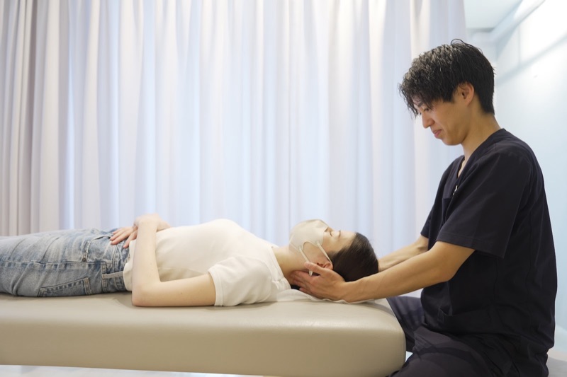 仰向けで首まわりを施術している様子